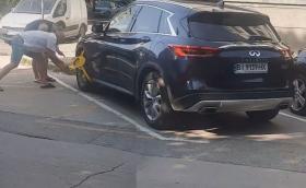 Двама мъже по джапанки чупят скоба във Варна, сложена на Infiniti QX60 (Видео)